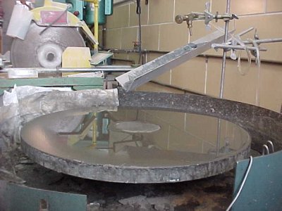 Another view of the glass lapping wheel, highlighting the slurry trough.